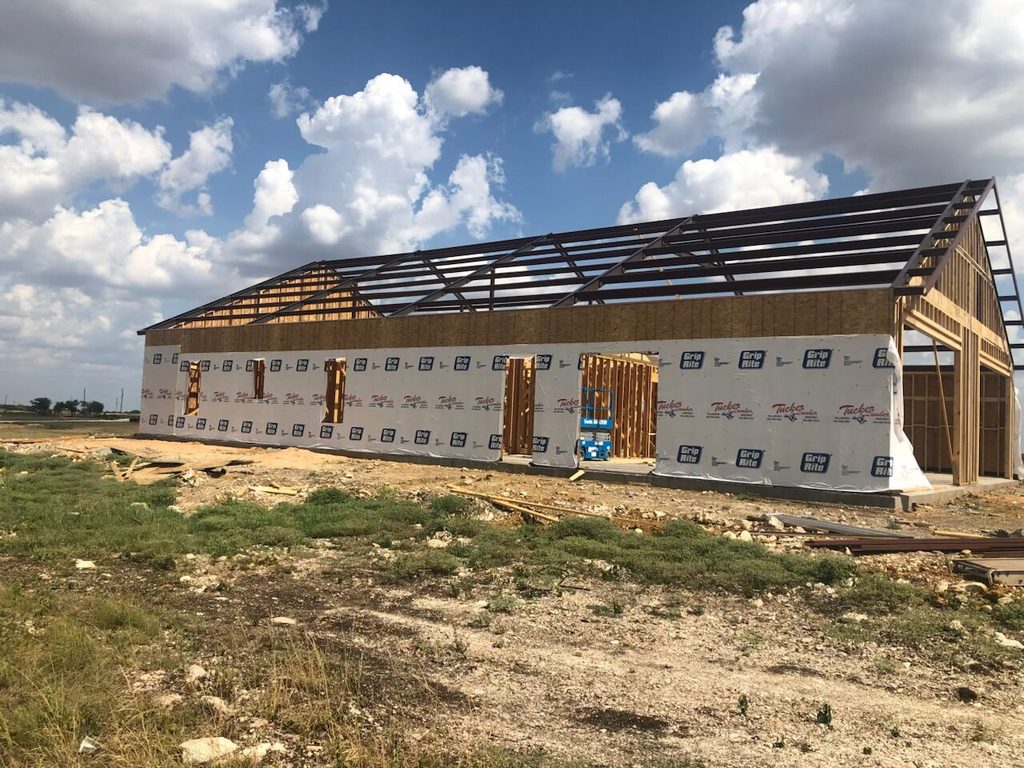 Barndominium under construction in Oklahoma with exposed roof framing and wall structure